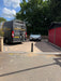 Ramco 600 black driveway security bollard installed at entrance to block-paved driveway with Bison Products installation van