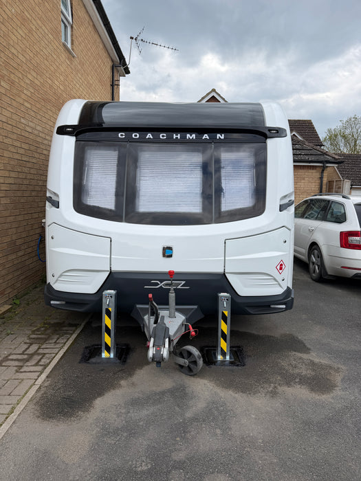Two Ramco 100 telescopic security bollards installed either side of a Coachman Xcel caravan on a residential driveway for theft deterrence