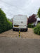 Ramco 100 telescopic security bollard with hi-vis tape installed on gravel driveway entrance protecting a Ford Transit Custom van
