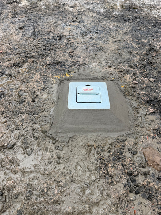 Ramco 100 telescopic security bollard retracted flush into ground housing with boxed lid set in fresh concrete during installation