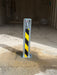 Ramco 100 galvanised telescopic security bollard with hi-vis yellow and black chevron tape installed inside a garage on concrete floor