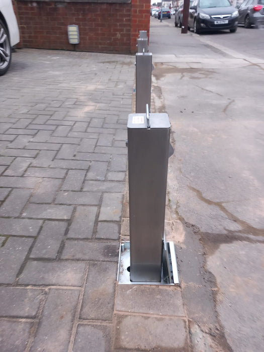 A stainless steel heavy duty security bollard installed by Bison Products on a concrete base with a protective lid and a high security lock.