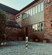 Ramco 100 driveway security bollard installed in gravel driveway at barn conversion.