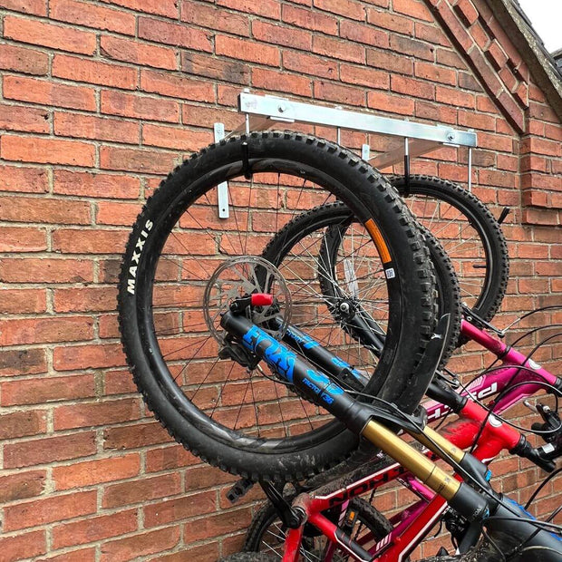 Vertical bike rack fixed to a brick wall